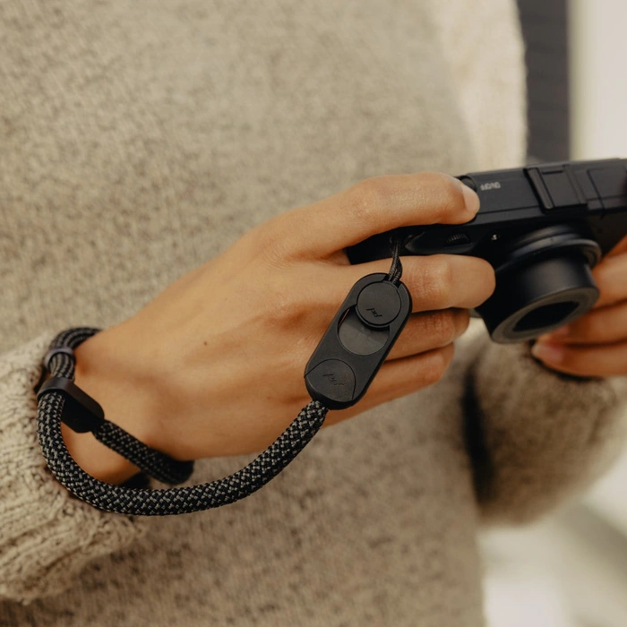 Person holding a camera with a Black Rope Cuff