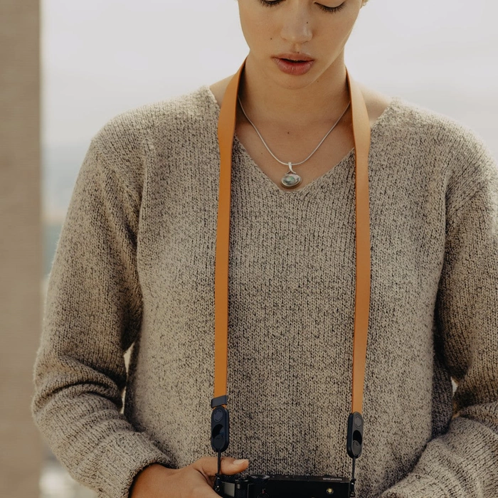 Person wearing a brown sweater with Amber Form Leather Strap Standard and holding a camera.