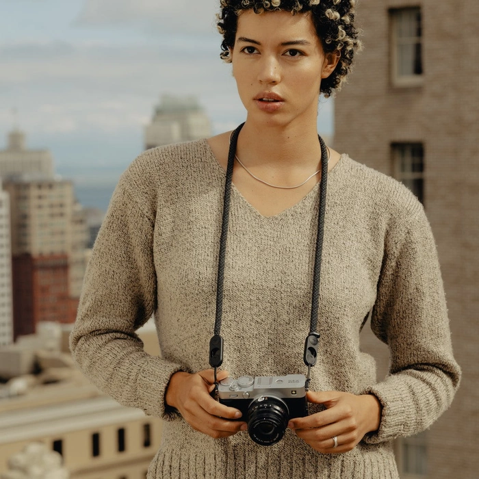Woman holding a camera attached to Short Black Rope Strap