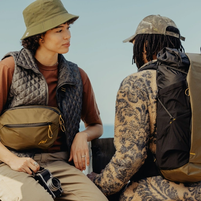 Lora and James wearing the Outdoor Sling 7L Kelp and Outdoor Backpack 45L Kelp