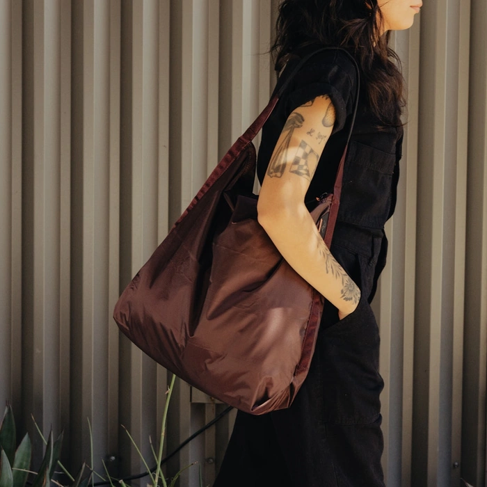 Person holding a Packable tote Eclipse against a neutral background